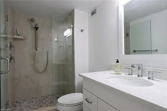 a bathroom with a sink a toilet and shower