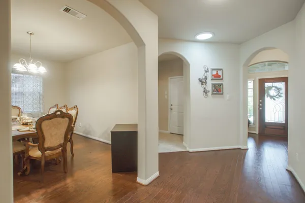 a view of a livingroom with a fireplace a ceiling fan and entryway