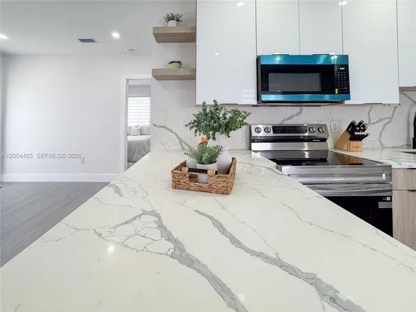 a kitchen with a stove and a white wooden cabinets