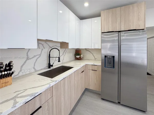 a kitchen with a refrigerator sink and cabinets