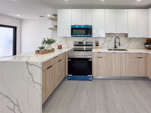 a kitchen with stainless steel appliances a sink dishwasher a stove and a refrigerator