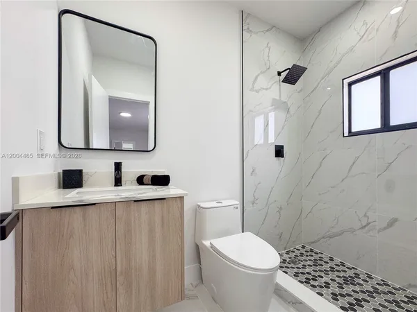 a bathroom with a toilet a sink and shower