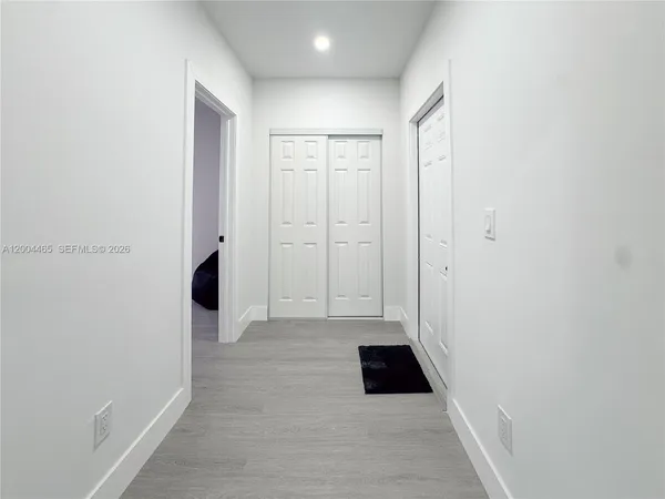 a view of empty room with wooden floor