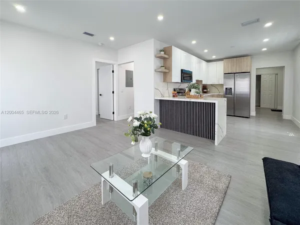 a kitchen with stainless steel appliances kitchen island granite countertop a refrigerator and a sink