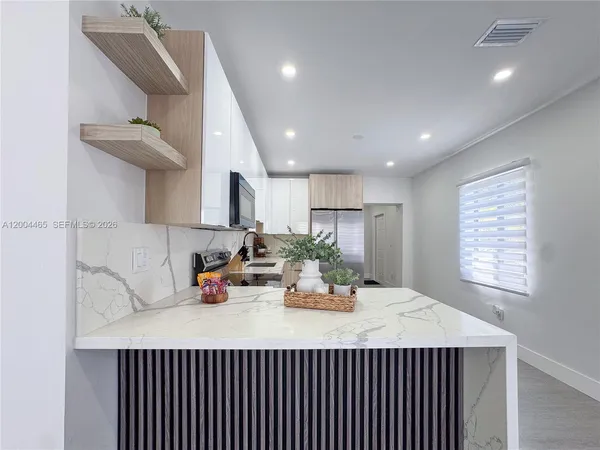 a kitchen with a sink dishwasher and a dining table with wooden floor
