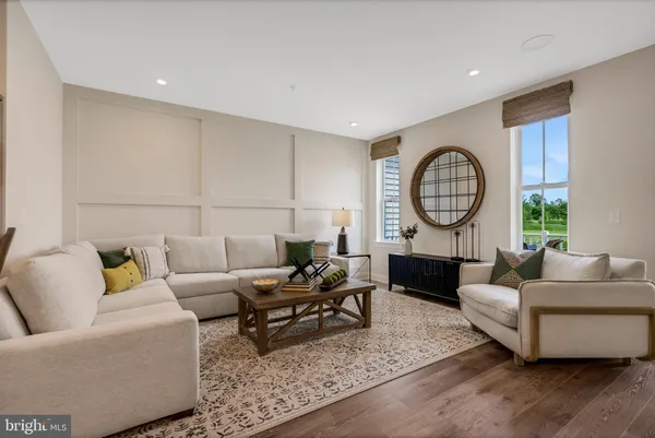 a living room with furniture a rug a lamp and a large window