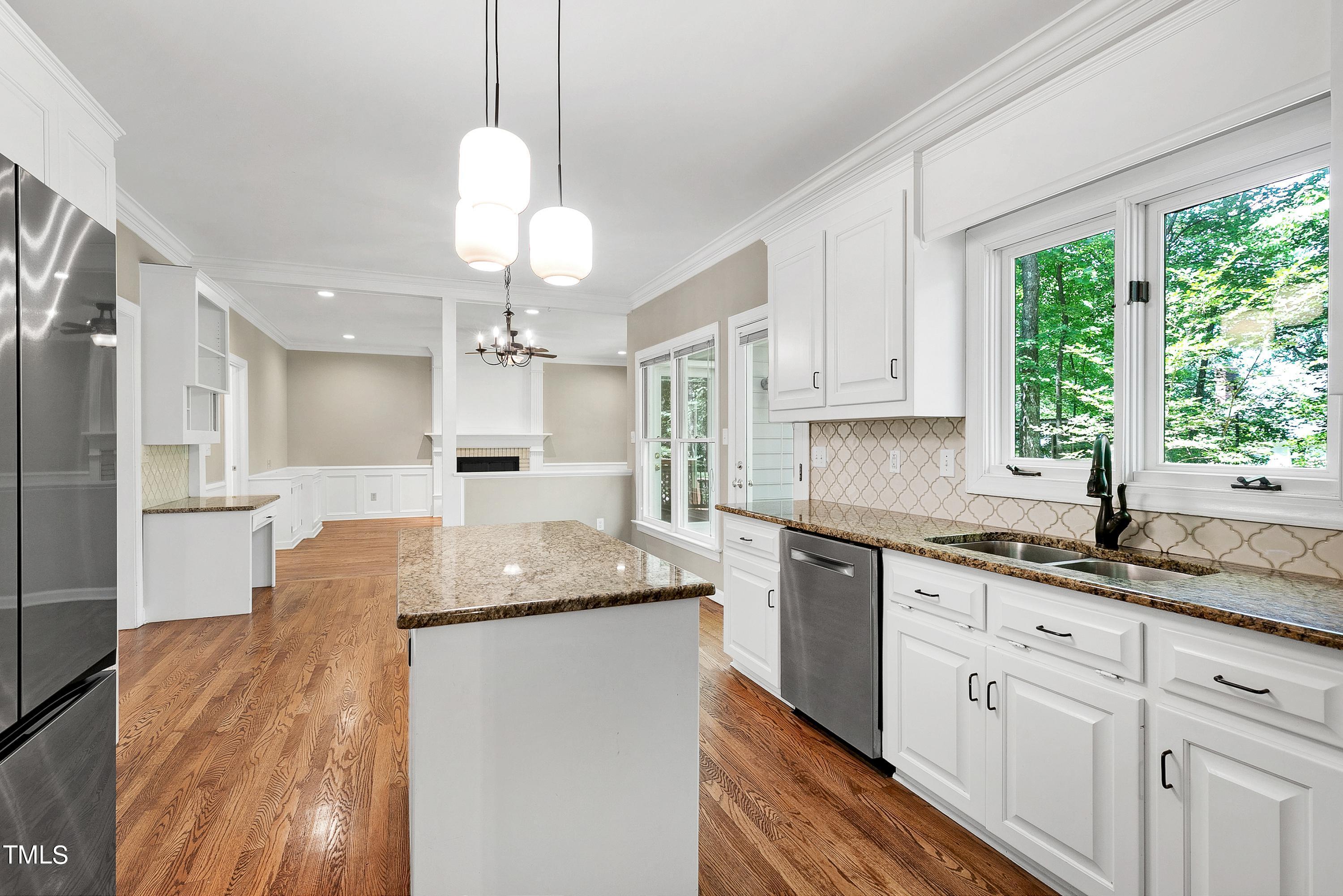 100 Buckden Place Cary, NC 27518 - Photo 18 of 70 a kitchen with granite countertop cabinets a sink dining table and a large window