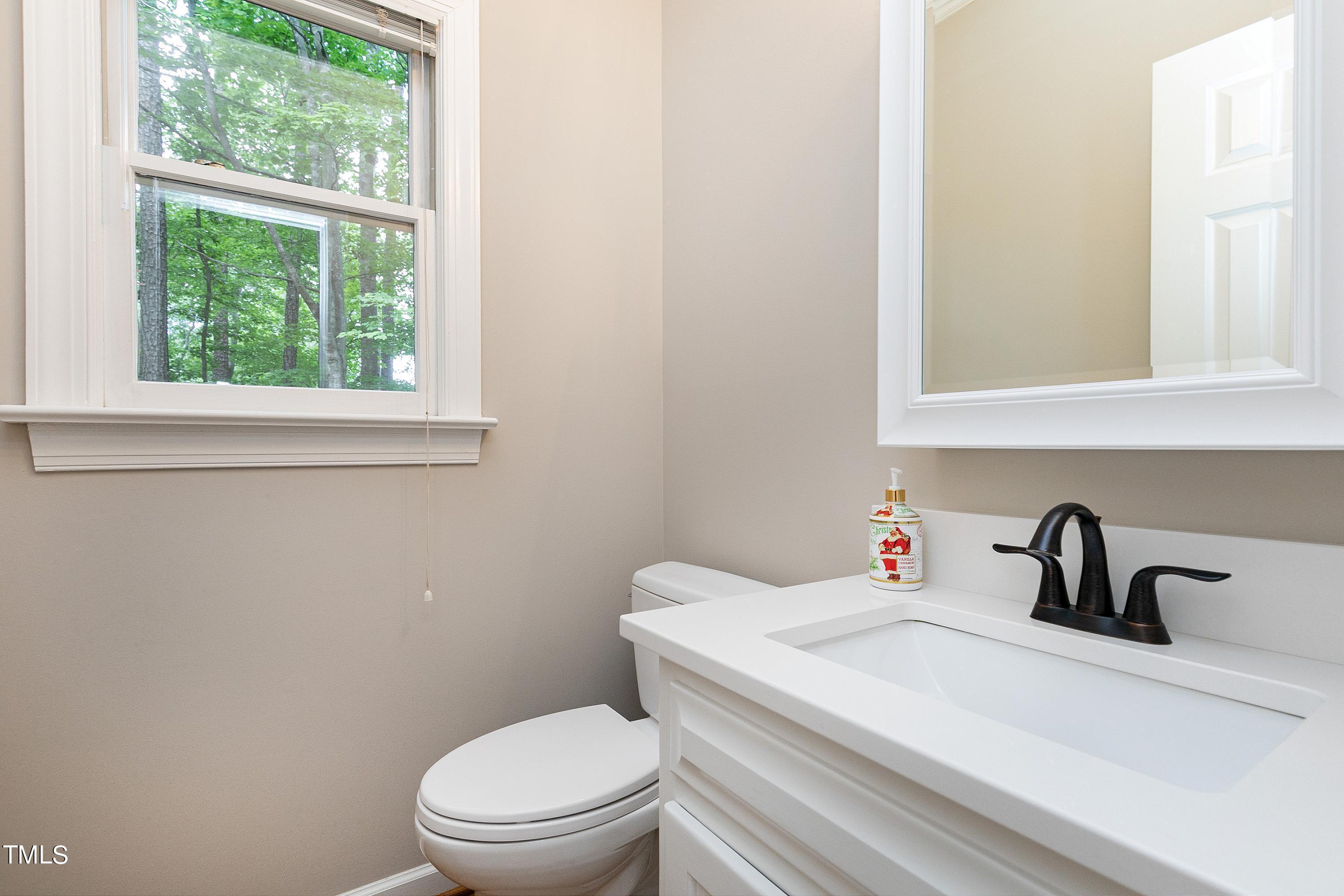 100 Buckden Place Cary, NC 27518 - Photo 21 of 70 a bathroom with a toilet sink and window
