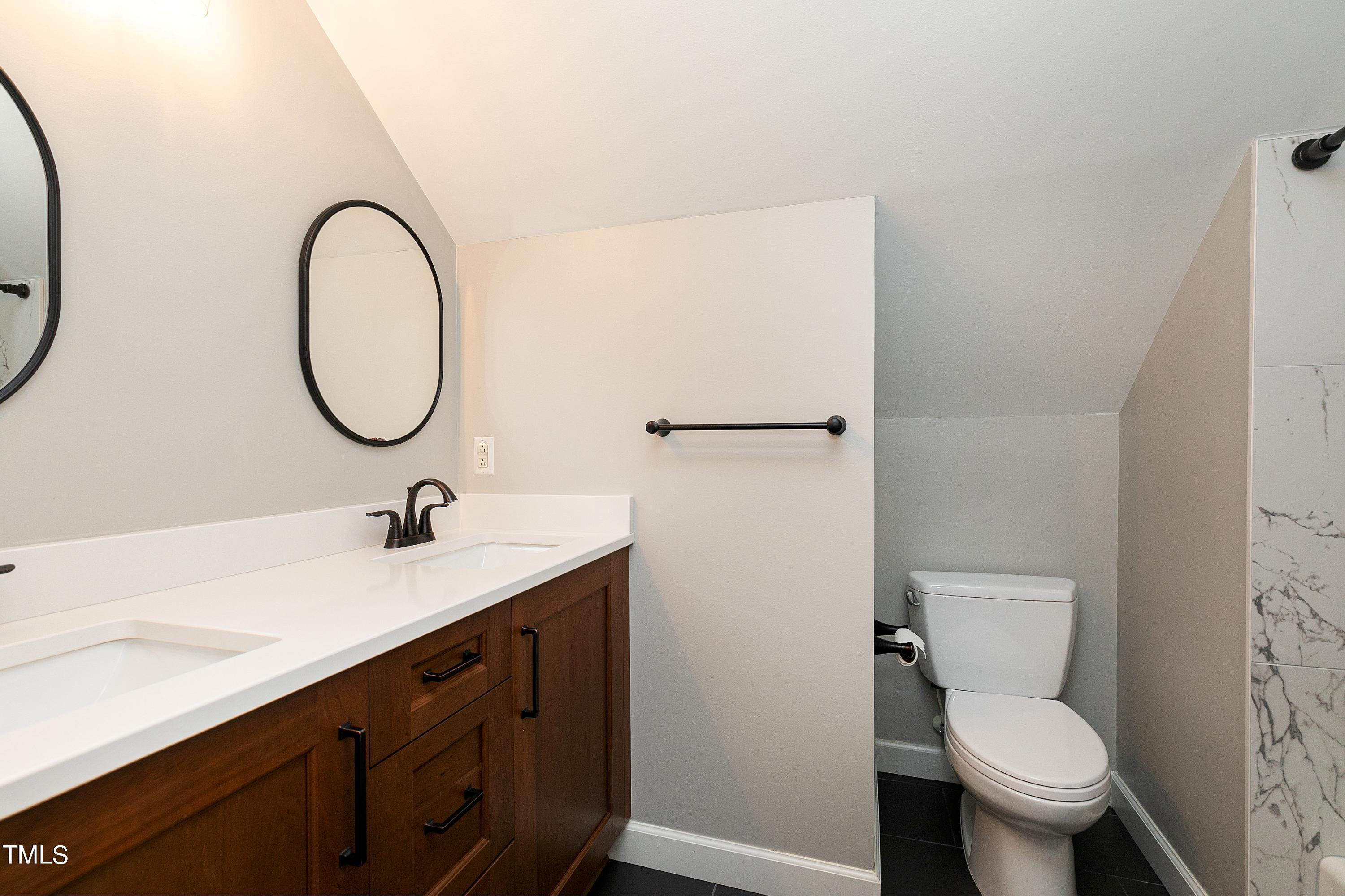 100 Buckden Place Cary, NC 27518 - Photo 39 of 70 a bathroom with a toilet a sink and a mirror