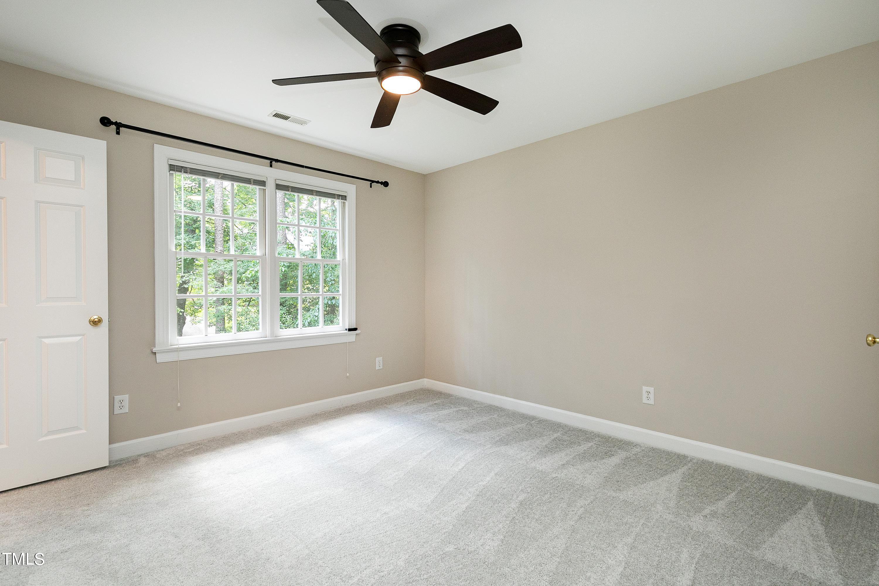 100 Buckden Place Cary, NC 27518 - Photo 41 of 70 an empty room with a window and a fan