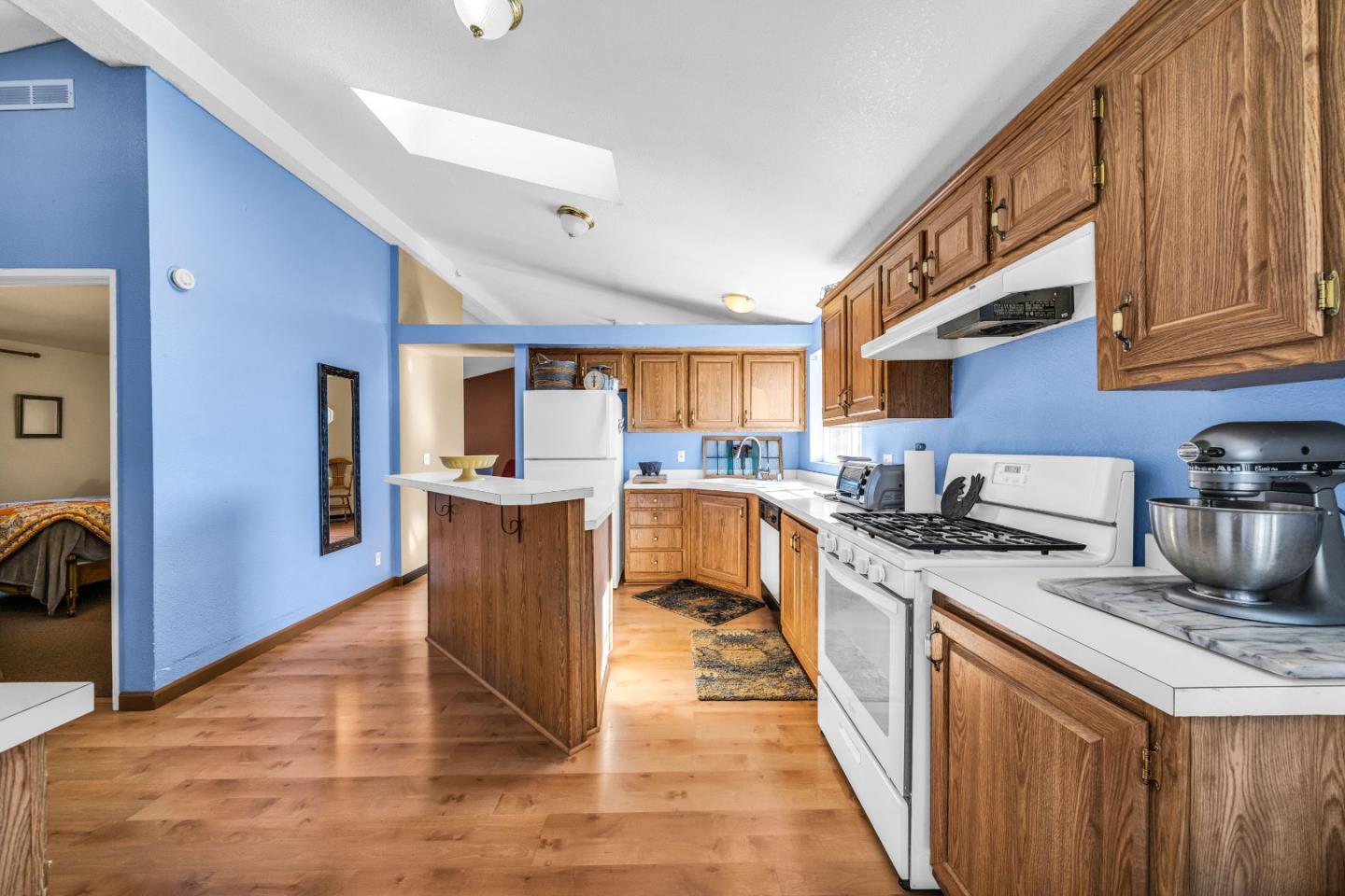 8645 Archer Road Salinas, CA 93907 - Photo 17 of 60 a kitchen with stainless steel appliances granite countertop a stove top oven a sink dishwasher a dining table and chairs with wooden floor