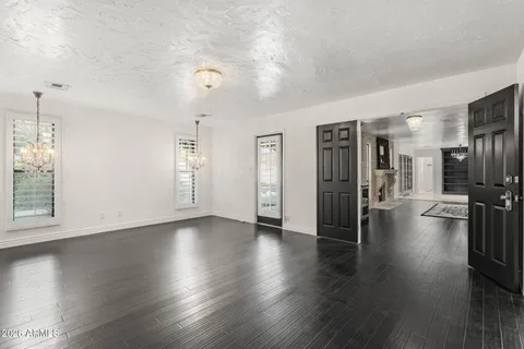 a view of a hallway with wooden floor and a chandelier