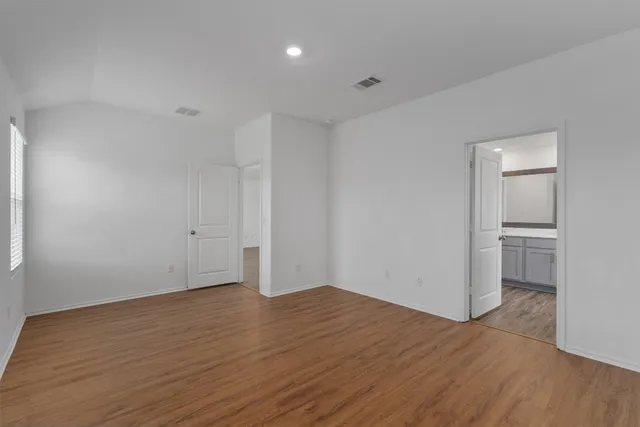 a view of empty room with wooden floor