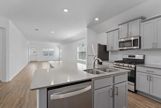 a kitchen that has a microwave a stove and white cabinets
