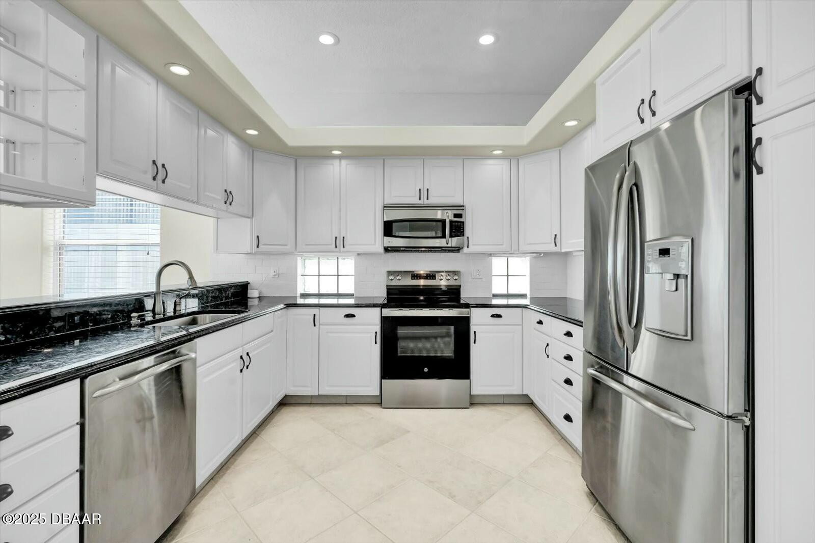 4363 South Atlantic Avenue Ponce Inlet, FL 32127 - Photo 11 of 46 a kitchen with granite countertop a refrigerator stove and sink