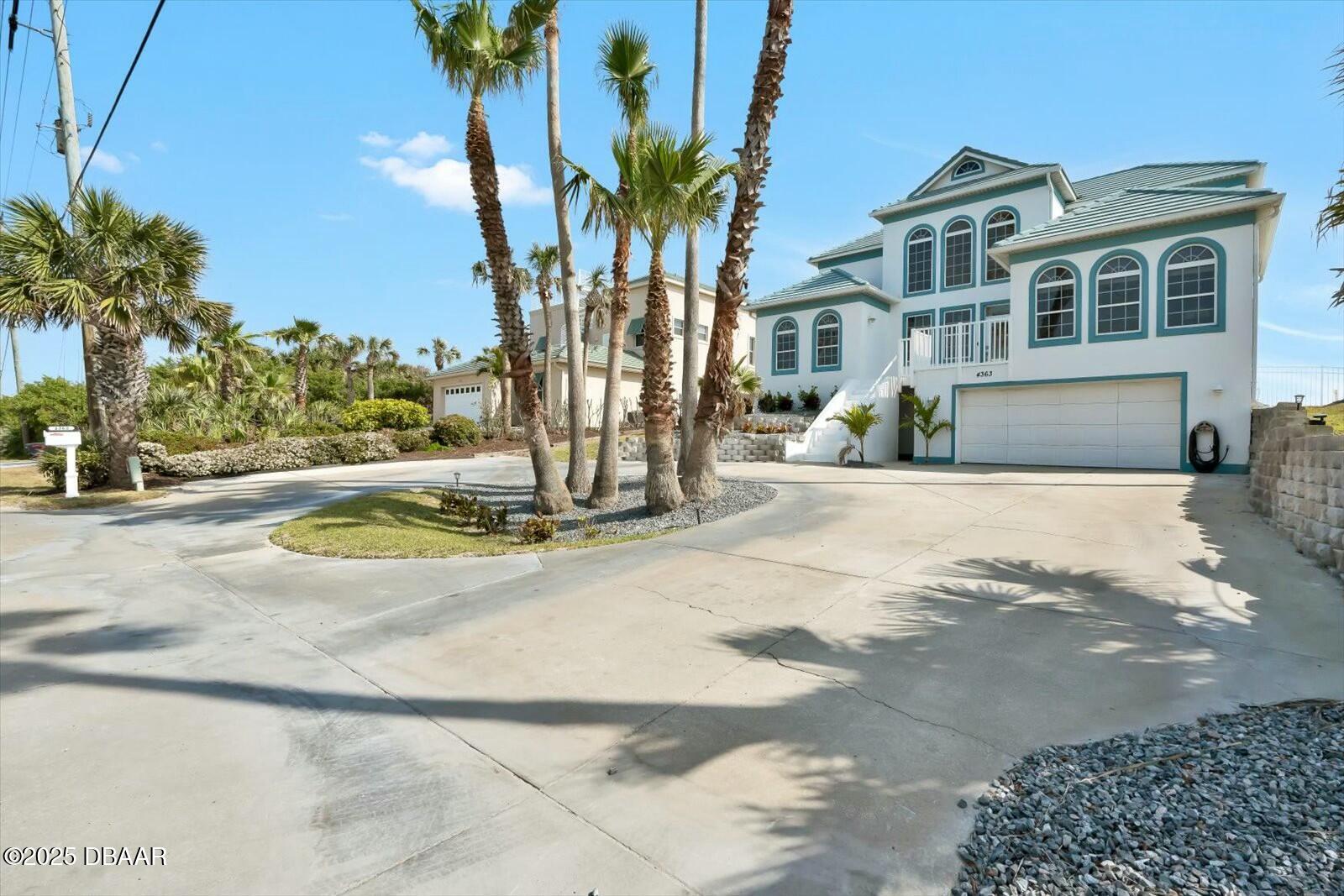 4363 South Atlantic Avenue Ponce Inlet, FL 32127 - Photo 32 of 46 a view of a white house with a yard and palm trees