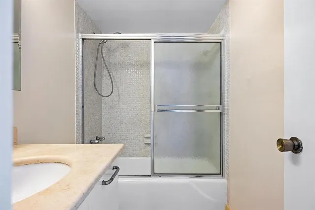 a bathroom with a granite countertop bathtub and a shower