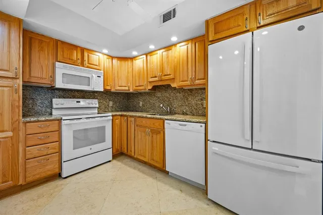 a kitchen with white cabinets and white appliances