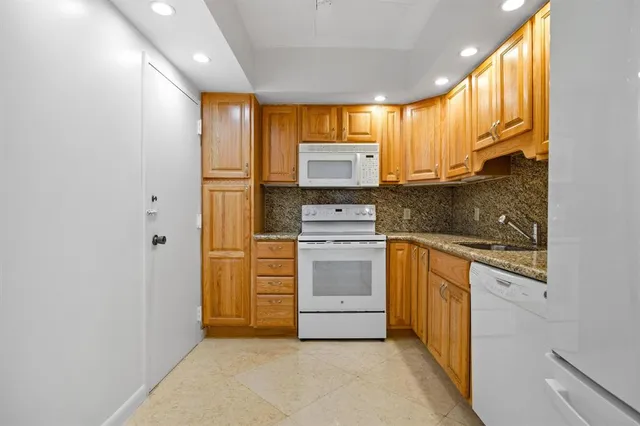 a kitchen with stainless steel appliances granite countertop a stove a sink and a refrigerator