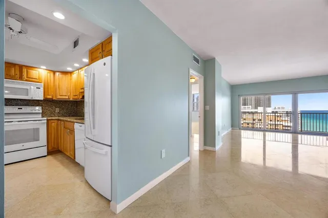 a kitchen with a refrigerator and white cabinets