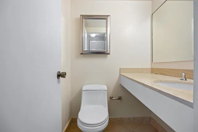 a bathroom with a toilet a sink and mirror