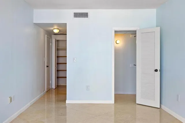 an empty room with closet and a bathroom