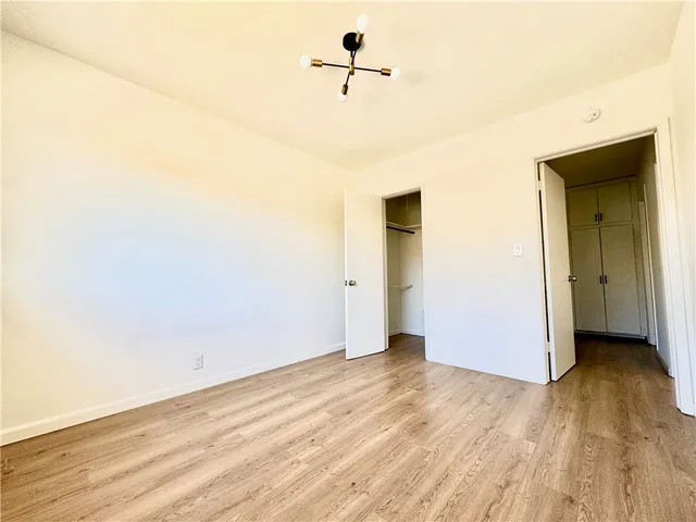 a view of a room with wooden floor and a ceiling fan