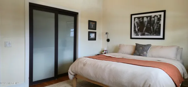 a bedroom with a bed and a painting on the wall