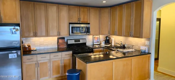 a kitchen with granite countertop wooden cabinets and a sink
