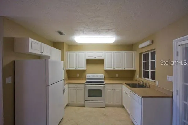 a kitchen with a refrigerator sink and stove top oven