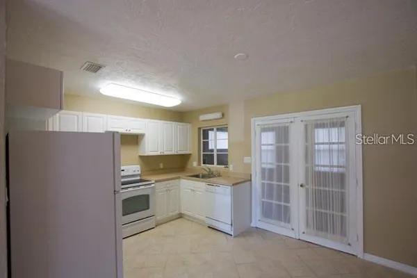 a kitchen with a sink cabinets stainless steel appliances and a window