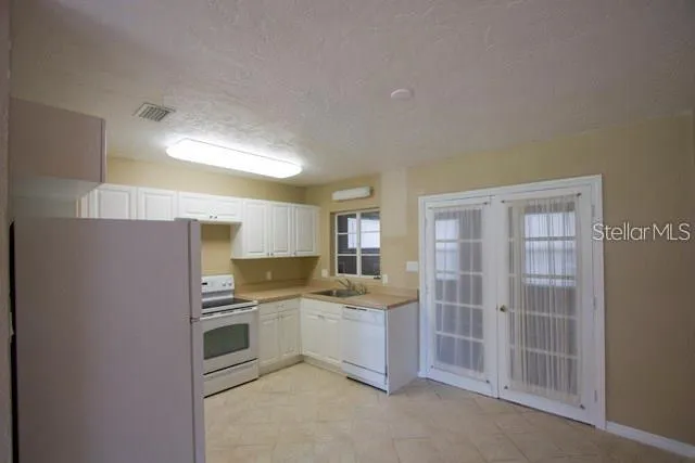 a kitchen with a sink cabinets stainless steel appliances and a window