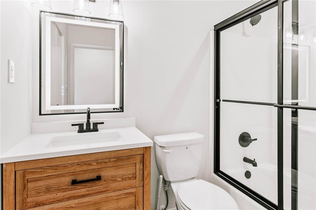 7820 Bethel Road Gainesville, GA 30506 - Photo 22 of 56 a bathroom with a sink a toilet a mirror and shower