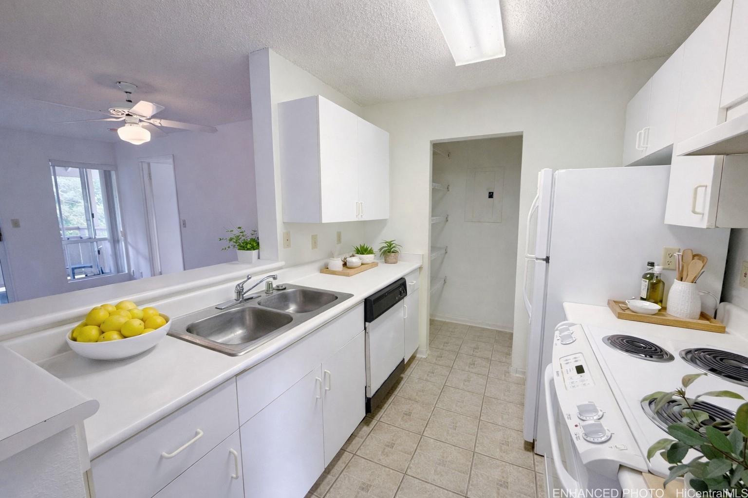95-510 Wikao Street, Unit Q206 Mililani, HI 96789 - Photo 4 of 19 a kitchen with a sink stove and cabinets