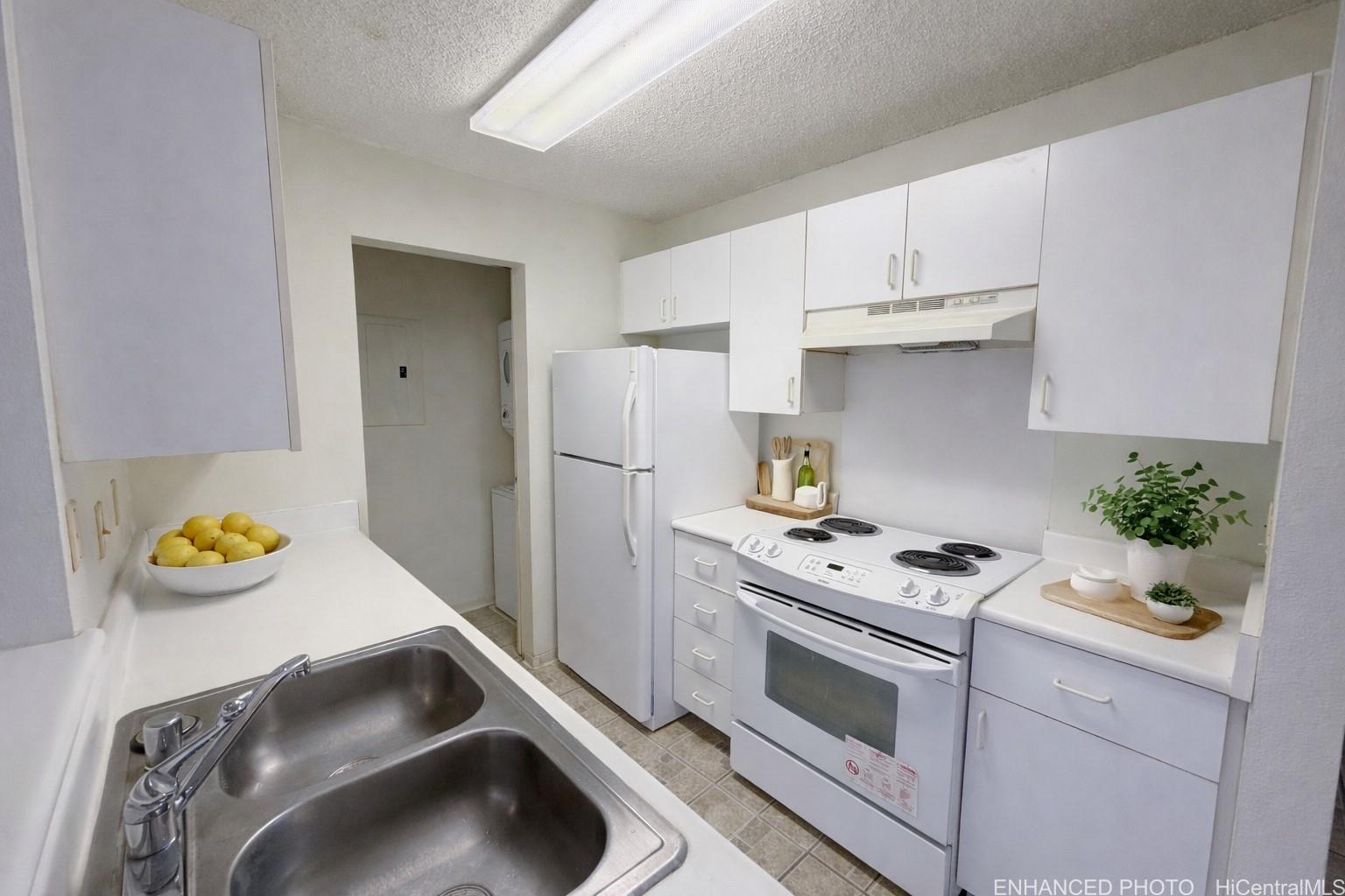 95-510 Wikao Street, Unit Q206 Mililani, HI 96789 - Photo 5 of 19 a kitchen with stainless steel appliances a stove a refrigerator and a sink