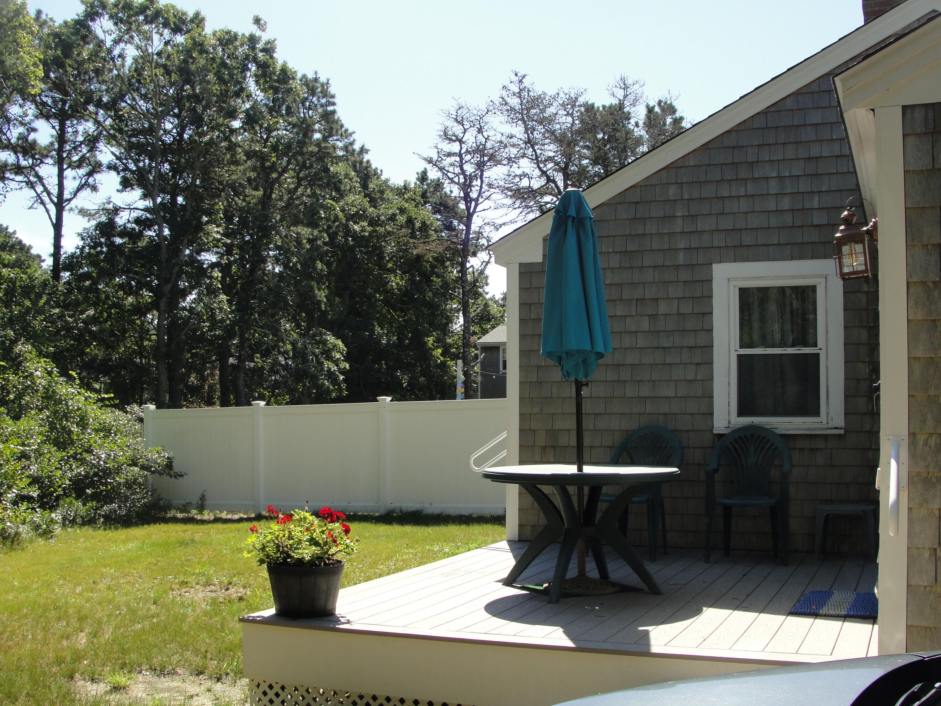 7 E Toms Path Dennis Port, MA 02639 - Photo 23 of 26 a view of a chair and table in backyard of the house