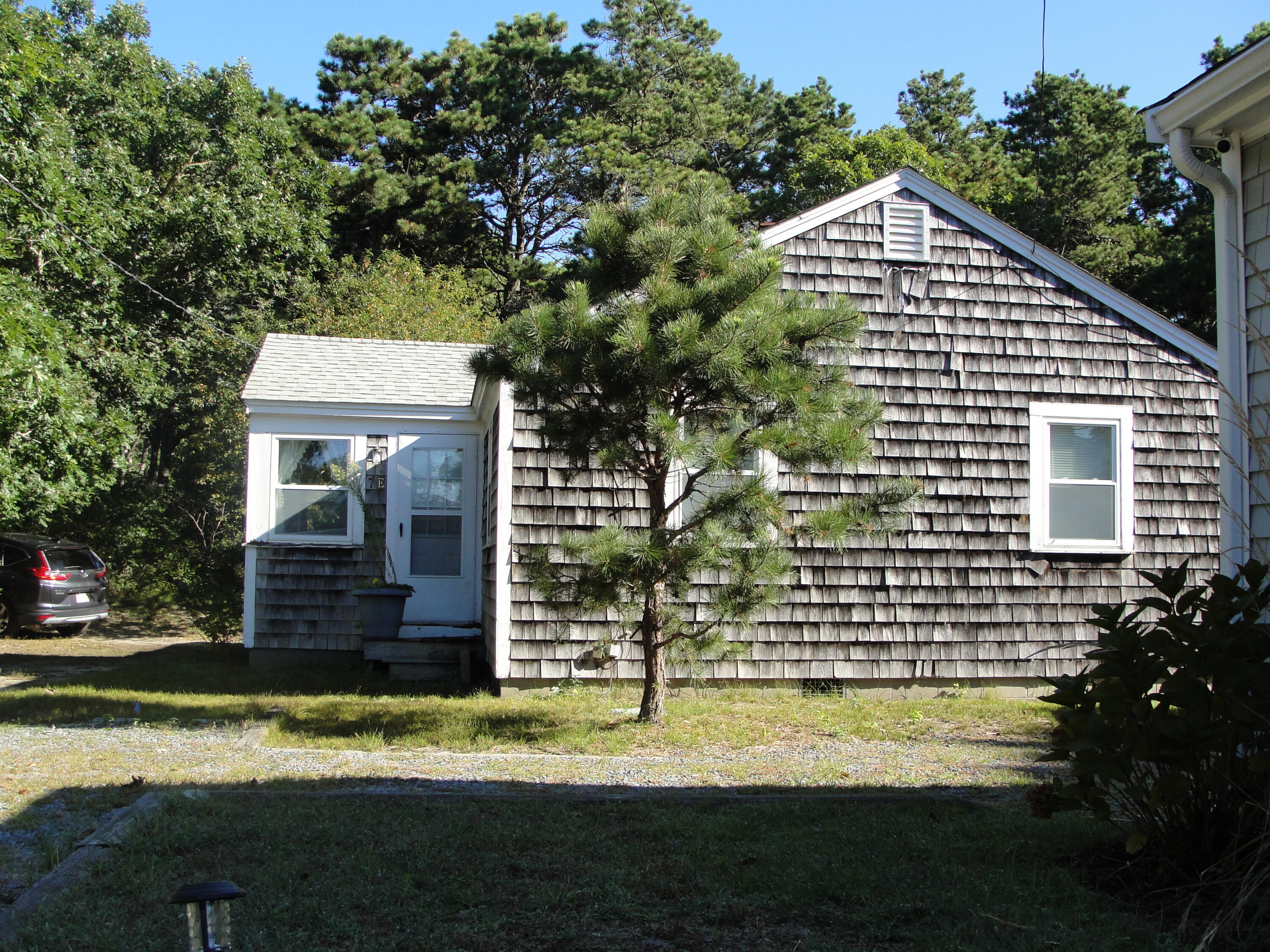 7 E Toms Path Dennis Port, MA 02639 - Photo 24 of 26 a front view of a house with a yard