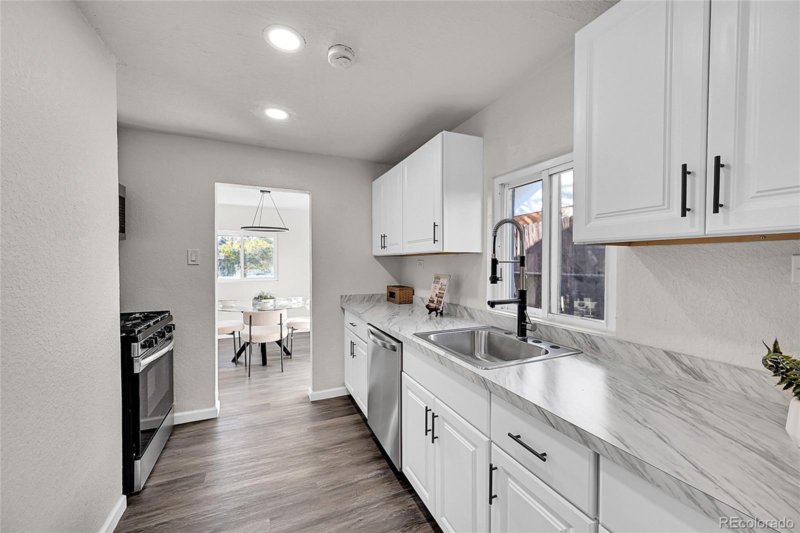 3984 Cook Street Denver, CO 80205 - Photo 12 of 29 a kitchen with sink a stove and cabinets