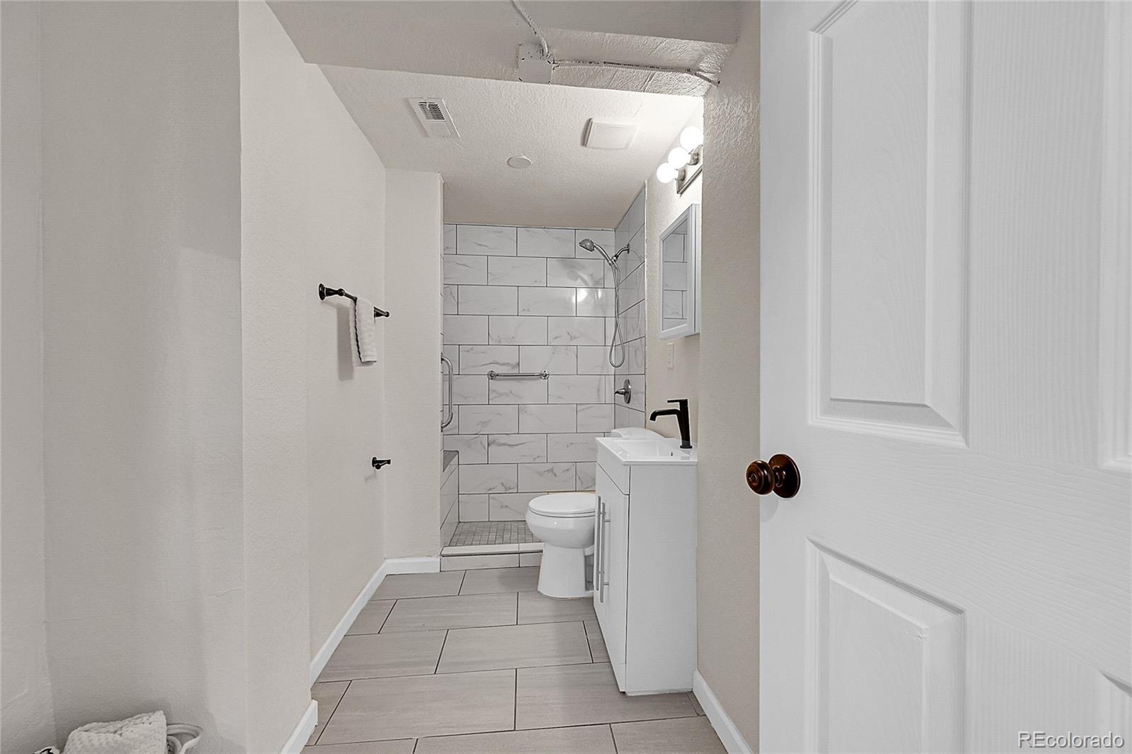 3984 Cook Street Denver, CO 80205 - Photo 17 of 29 a bathroom with a shower and toilet