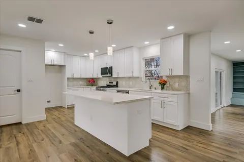 a kitchen with cabinets and wooden floor