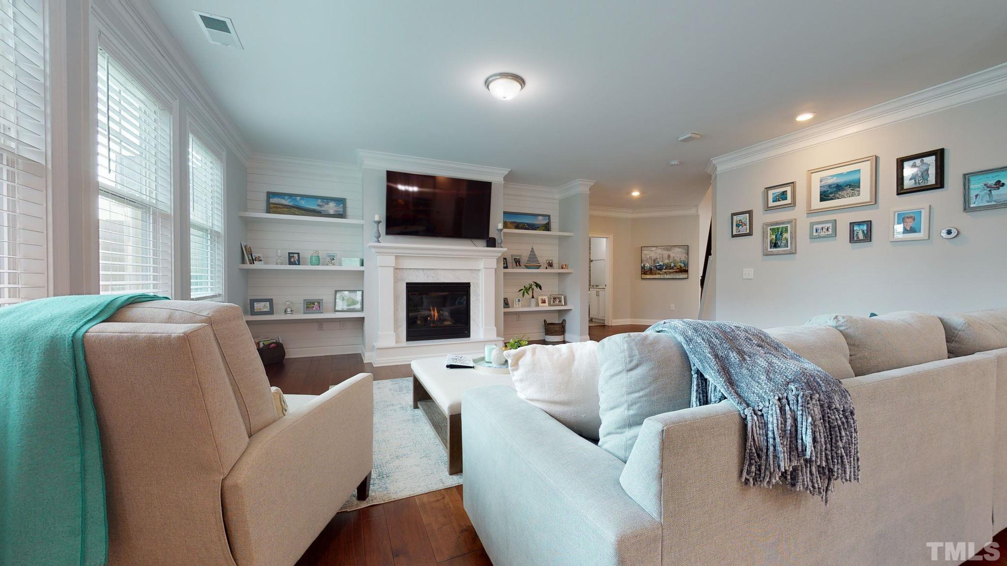 2351 Terrmini Drive Apex, NC 27502 - Photo 11 of 30 a living room with furniture a fireplace and a flat screen tv