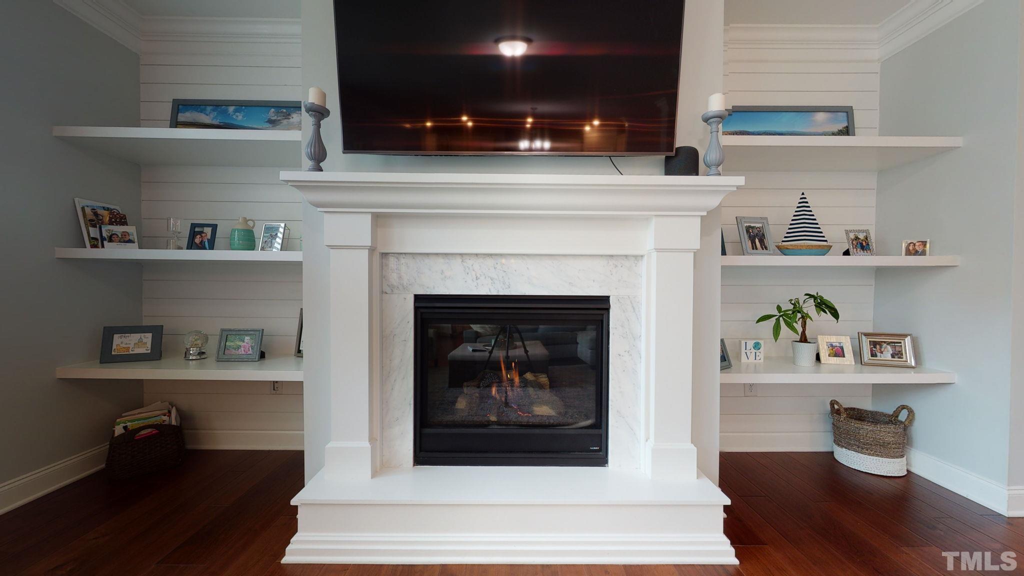 2351 Terrmini Drive Apex, NC 27502 - Photo 13 of 30 a living room with a fireplace and a wooden floor