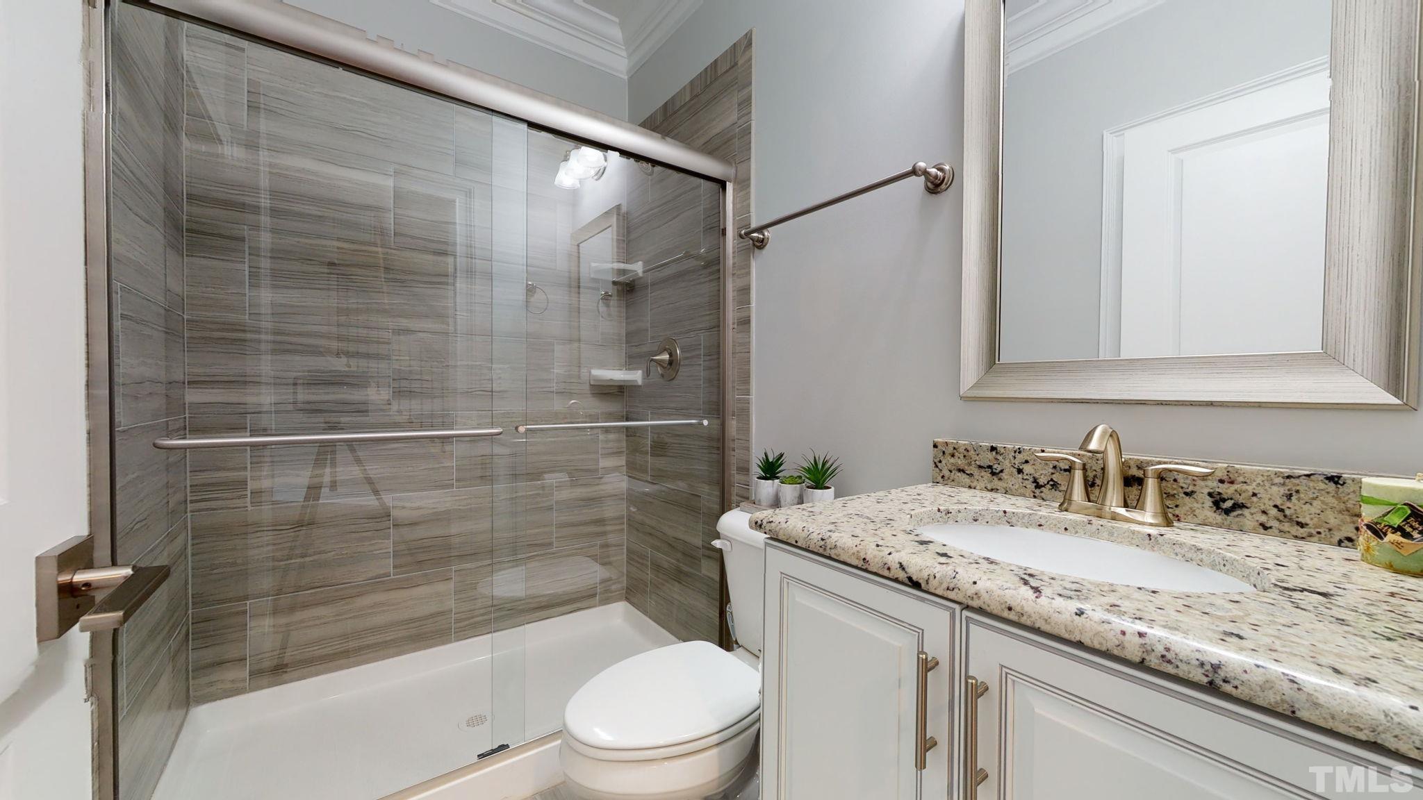 2351 Terrmini Drive Apex, NC 27502 - Photo 15 of 30 a bathroom with a granite countertop sink a toilet and shower