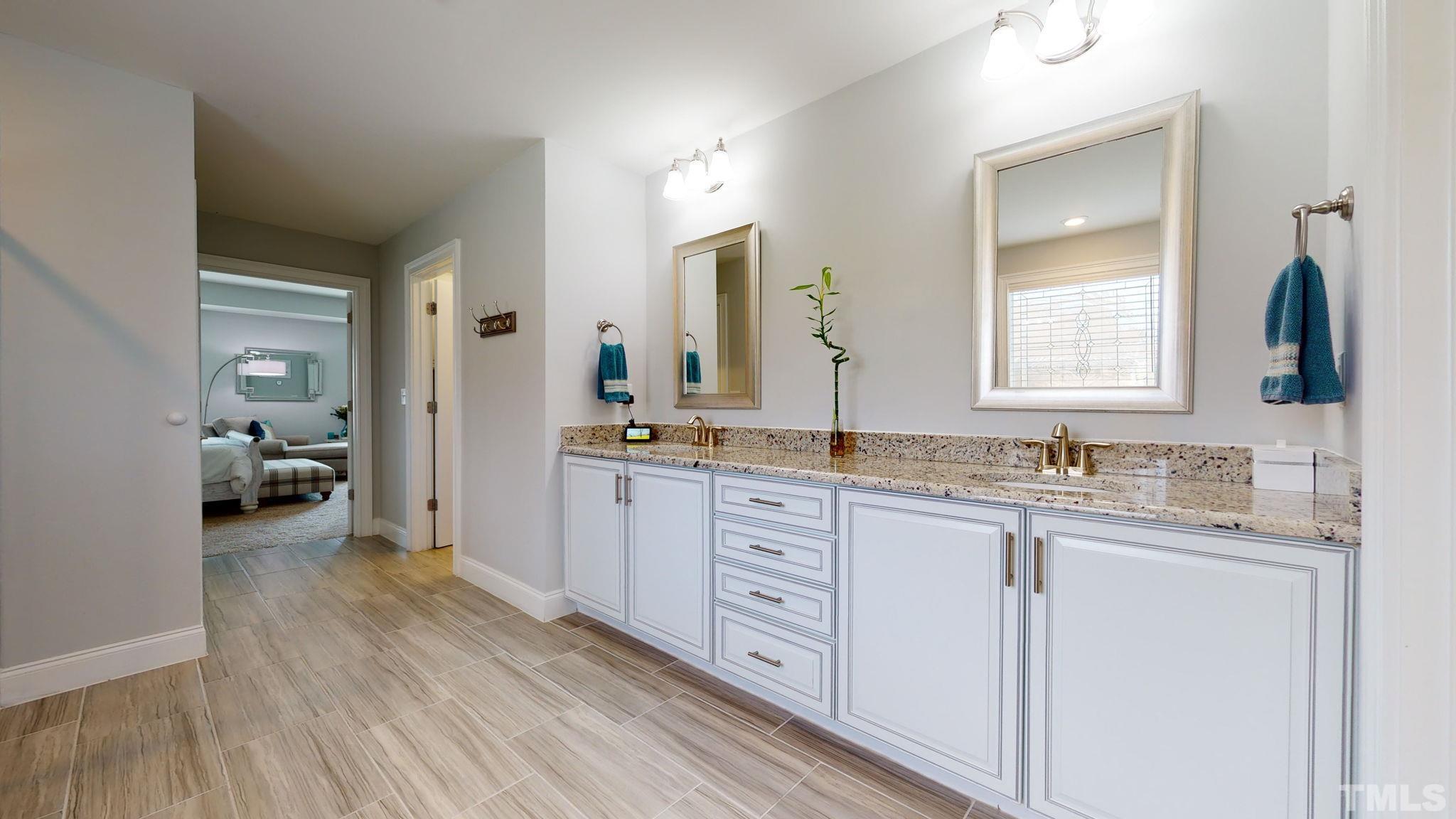 2351 Terrmini Drive Apex, NC 27502 - Photo 19 of 30 a en suite bathroom with a granite countertop sink and a mirror
