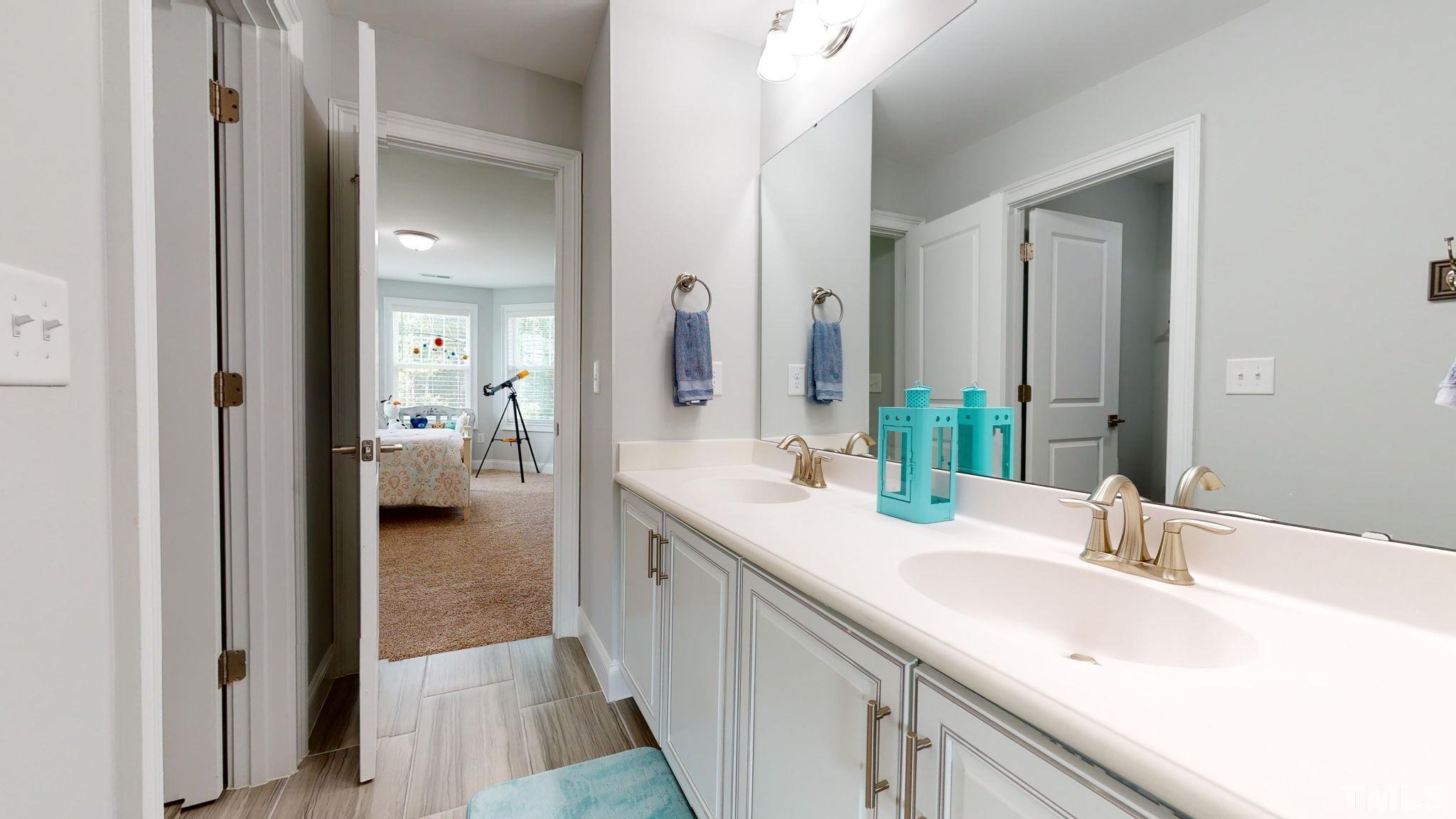 2351 Terrmini Drive Apex, NC 27502 - Photo 23 of 30 a en suite bathroom with a sink and a mirror