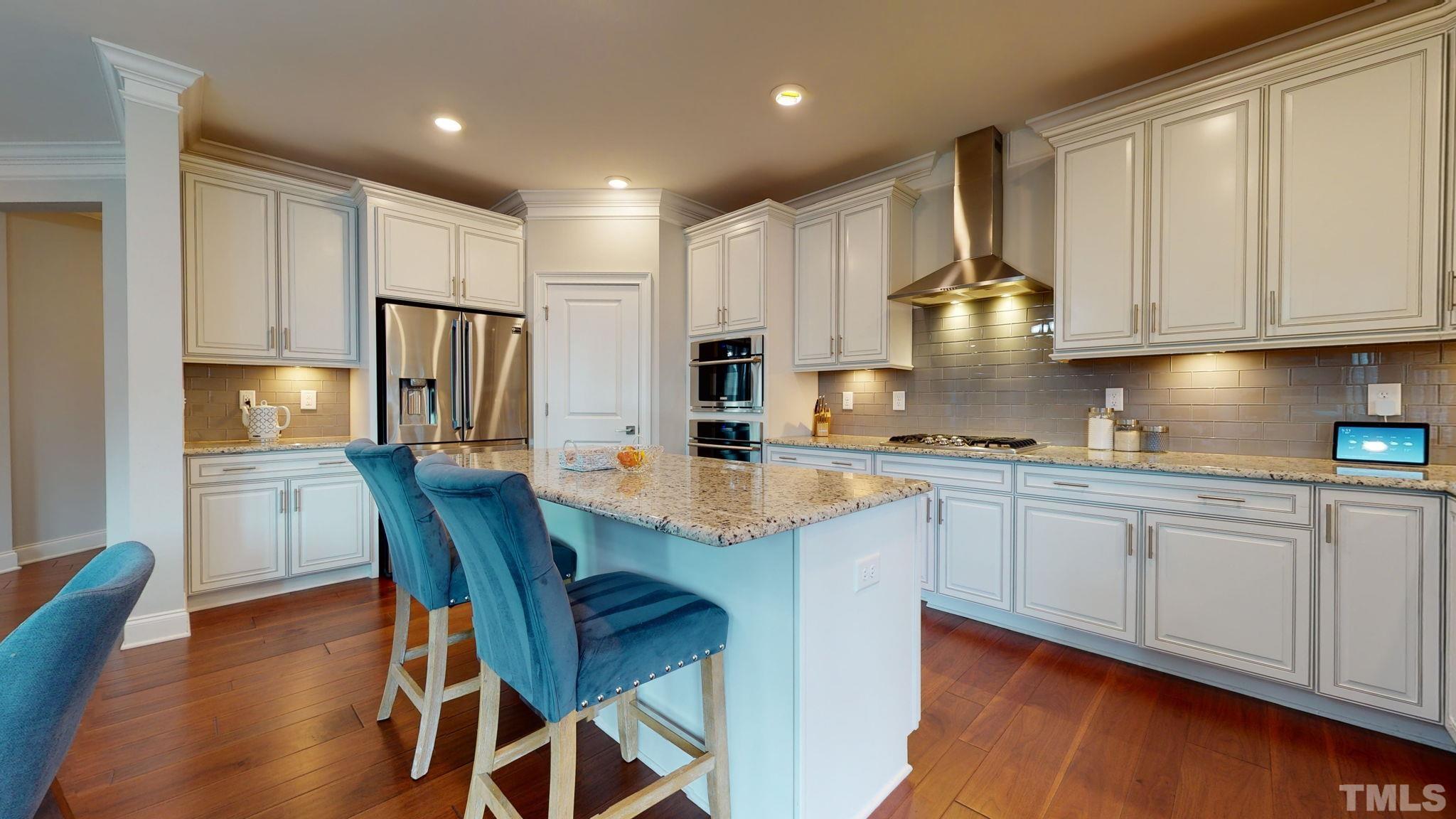 2351 Terrmini Drive Apex, NC 27502 - Photo 9 of 30 a kitchen with stainless steel appliances granite countertop a stove a sink dishwasher a refrigerator and white cabinets with wooden floor