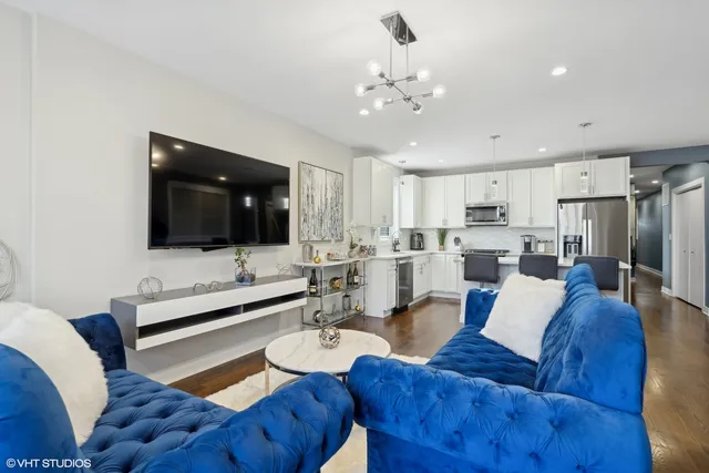 a kitchen with stainless steel appliances granite countertop a refrigerator a stove a sink dishwasher and a refrigerator with wooden floor