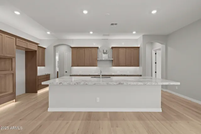 a living room with stainless steel appliances kitchen island a large window and a fireplace