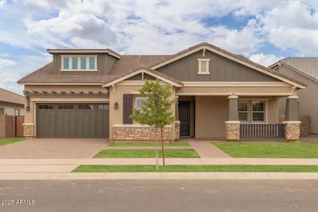 a front view of a house with a garden and trees