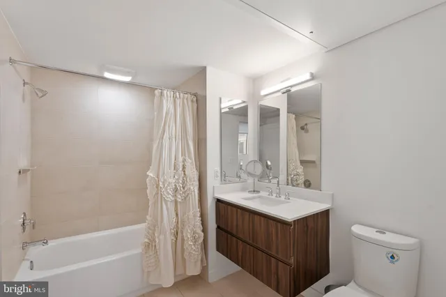 a bathroom with a sink double vanity mirror and a bathtub